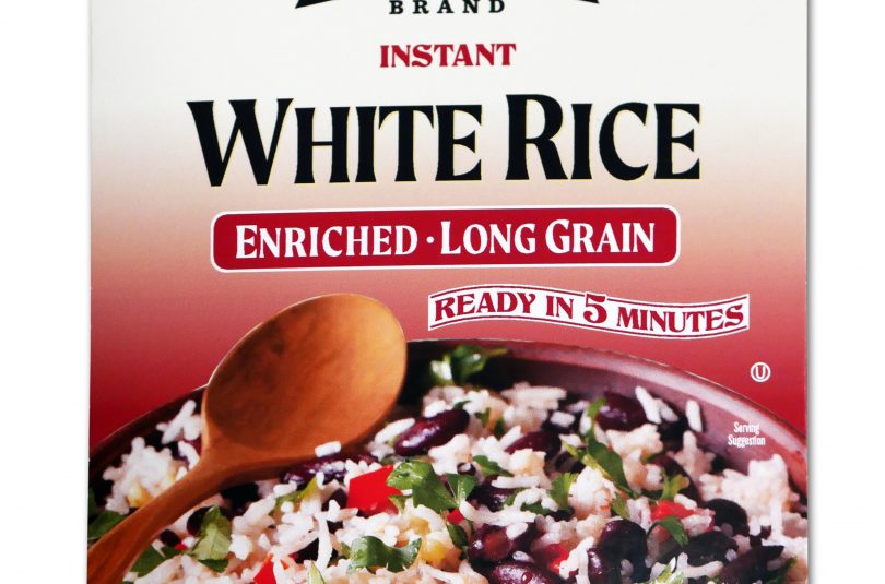 Red package of Jack Rabbit Brand Instant White Rice. The box reads, "Gluten Free - Non-GMO - Precooked, Jack Rabbit Brand Instant White Rice, enriched - long grain, ready in 5 minutes." The box has an image of a white rice dish with black beans and vegetables.